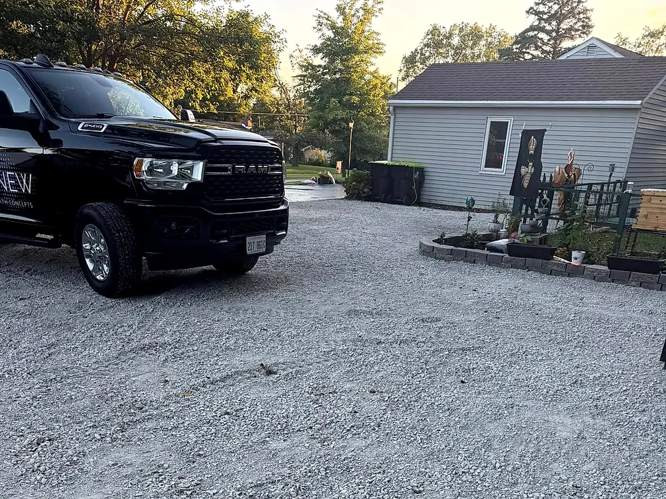 Golden-hour residential driveway, deep black seal coat