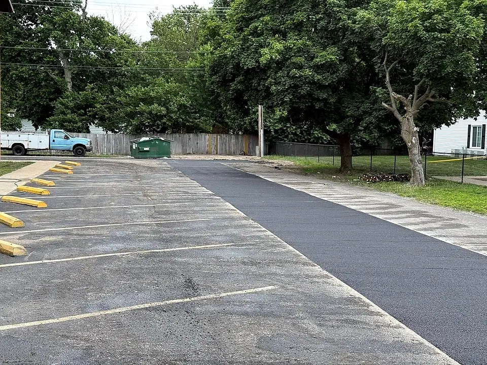 Freshly sealed drive lane with new yellow speed bumps and parking lines