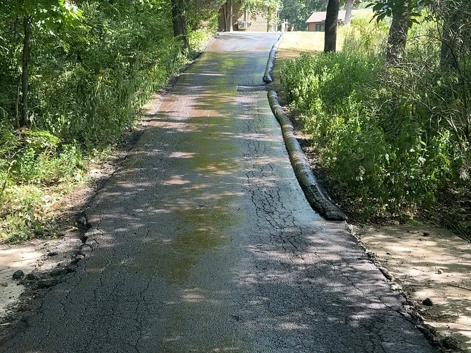 Fresh dark asphalt meeting the edge during paving