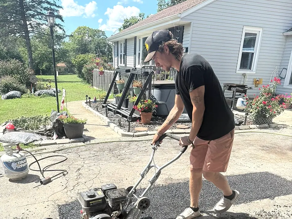 Crew member working the spreader on a residential driveway